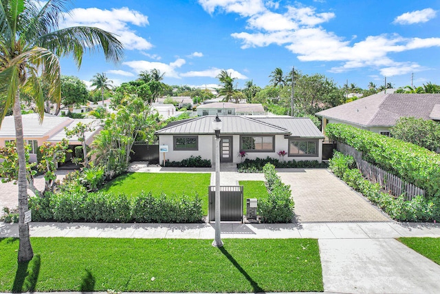 view of front of property featuring a front yard, a fenced front yard, driveway, and stucco siding