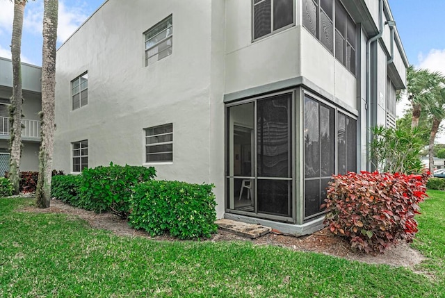 back of property with a yard and stucco siding