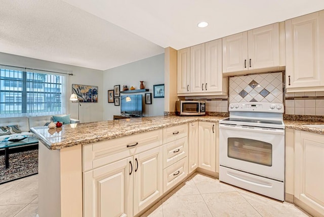 kitchen with white electric stove, light tile patterned flooring, a peninsula, open floor plan, and stainless steel microwave