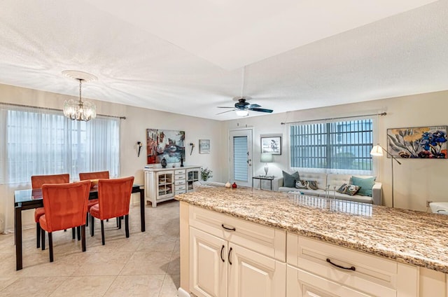 kitchen featuring light tile patterned floors, plenty of natural light, and light stone countertops