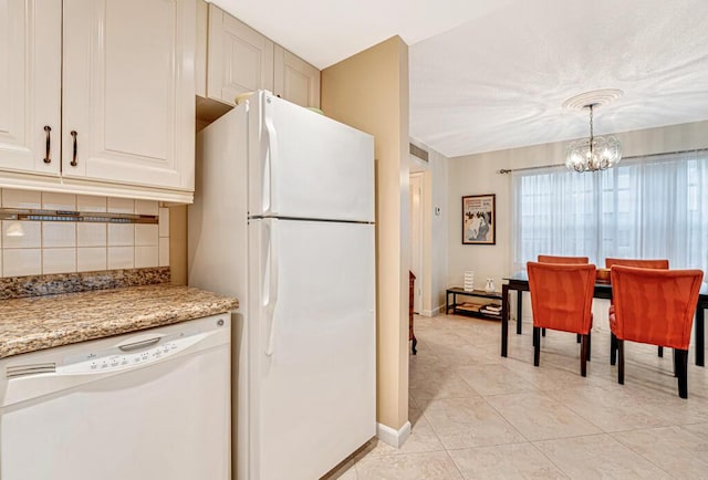 kitchen with light tile patterned floors, a notable chandelier, white appliances, hanging light fixtures, and decorative backsplash