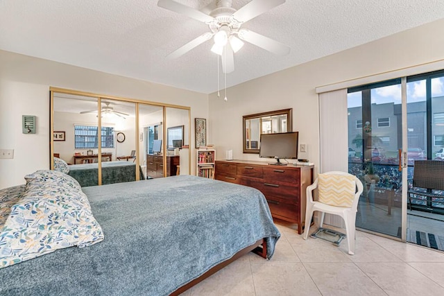 bedroom with light tile patterned floors, ceiling fan, access to outside, a textured ceiling, and a closet