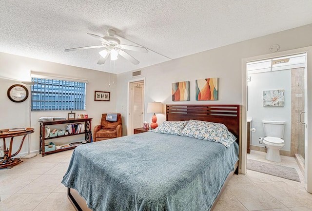 bedroom featuring a textured ceiling, light tile patterned flooring, visible vents, and a ceiling fan