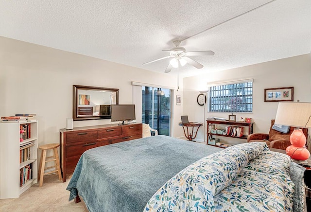 bedroom featuring access to exterior, ceiling fan, and a textured ceiling