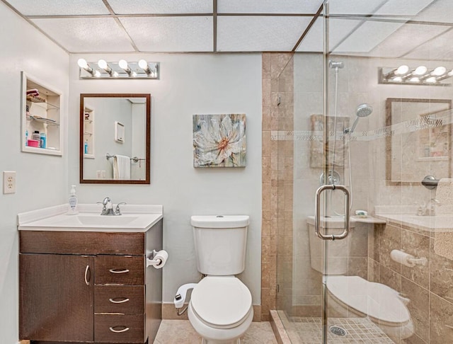 bathroom with toilet, a shower stall, vanity, tile patterned flooring, and baseboards