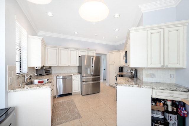 kitchen with light tile patterned floors, appliances with stainless steel finishes, a sink, and ornamental molding