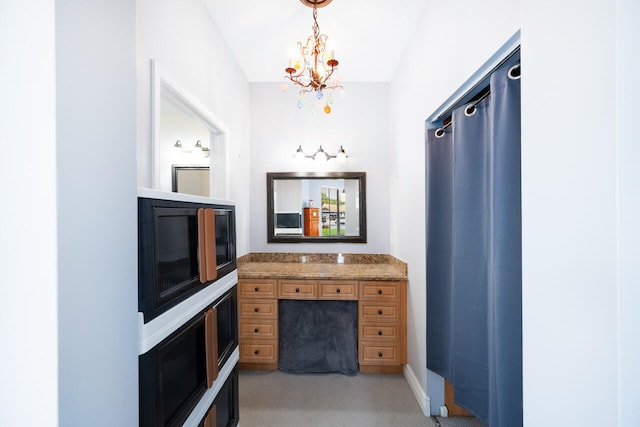 bathroom with a chandelier and vanity