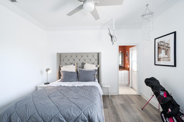 bedroom with ensuite bath, baseboards, crown molding, and wood finished floors