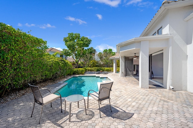 view of swimming pool featuring ceiling fan, a patio area, and a fenced in pool