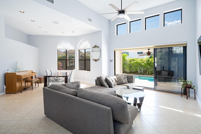 living area with baseboards, a ceiling fan, and light tile patterned flooring