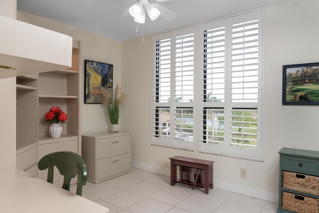 home office with baseboards, a ceiling fan, and light tile patterned flooring