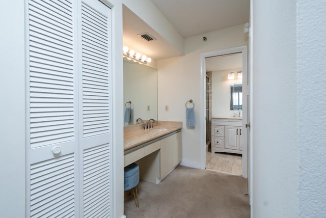 bathroom featuring a closet, visible vents, vanity, and baseboards