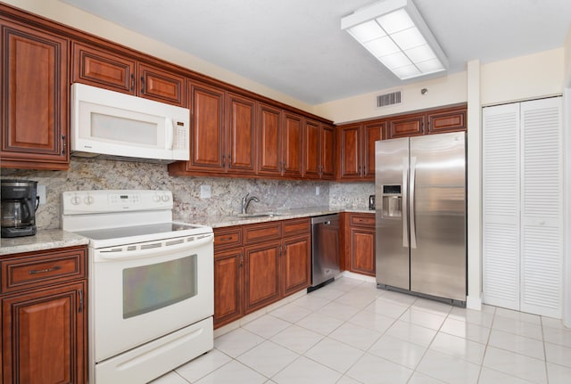 kitchen featuring light tile patterned floors, stainless steel appliances, tasteful backsplash, visible vents, and a sink