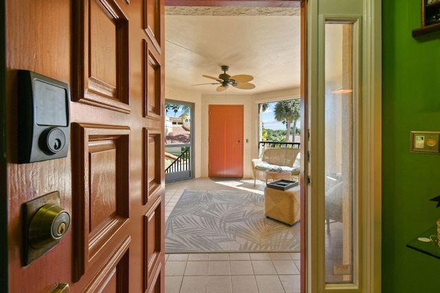 doorway to outside with light tile patterned flooring and a ceiling fan