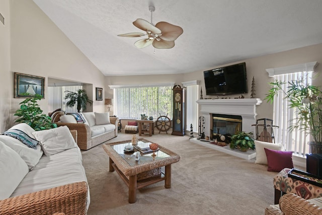 carpeted living room with a glass covered fireplace, a textured ceiling, a ceiling fan, and high vaulted ceiling