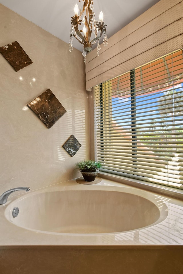 full bathroom with a chandelier and a bathing tub