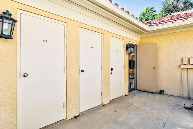 entrance to property with stucco siding and a tiled roof