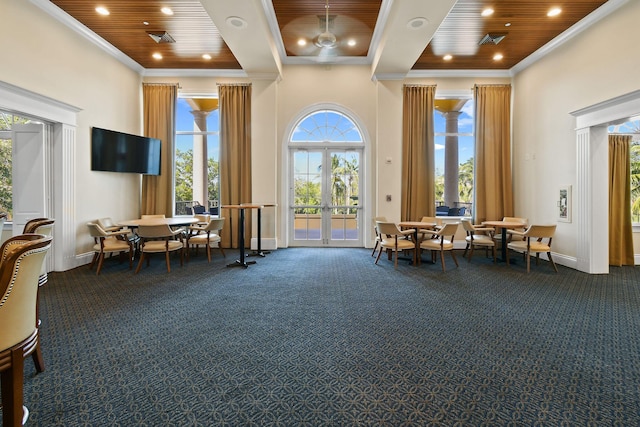 sitting room featuring dark colored carpet, wooden ceiling, and crown molding