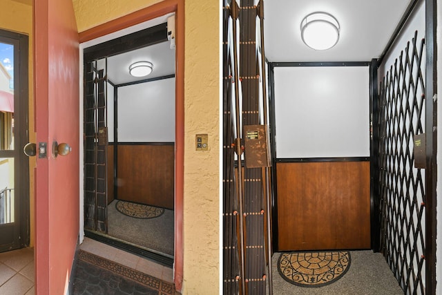 interior details featuring elevator and a textured wall