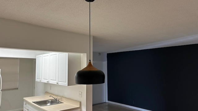 room details with a textured ceiling, baseboards, and a sink