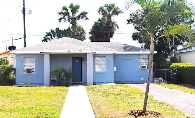 view of front of property featuring a front lawn, cooling unit, fence, and stucco siding