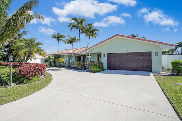 ranch-style house with stucco siding, an attached garage, and concrete driveway