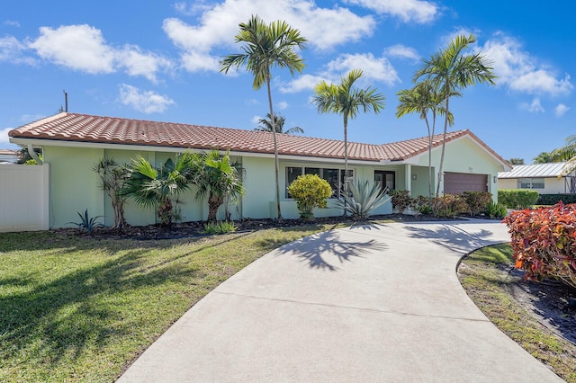 view of front facade featuring a front lawn, fence, a tile roof, and stucco siding