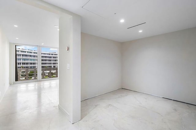 unfurnished room featuring floor to ceiling windows and recessed lighting