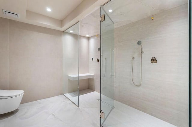 bathroom featuring a shower with shower door, visible vents, and toilet