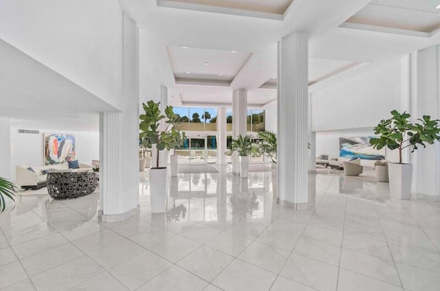 foyer entrance with light tile patterned floors, visible vents, and a raised ceiling