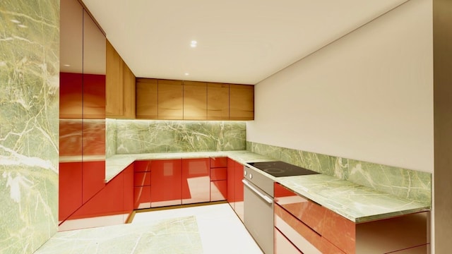 kitchen with light countertops, decorative backsplash, red cabinetry, oven, and black electric cooktop