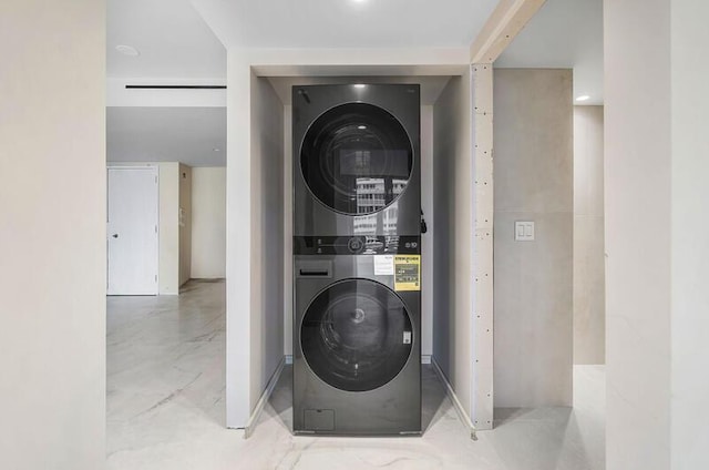 utility room with stacked washer and dryer