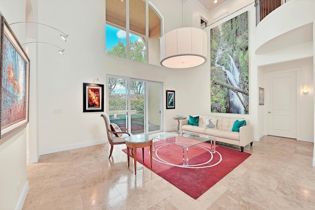 living area with baseboards and a high ceiling