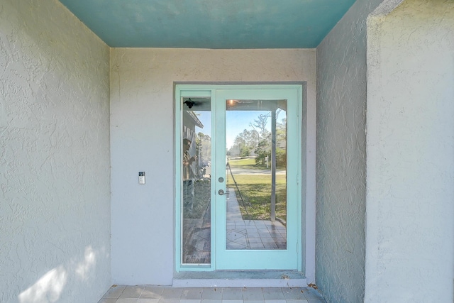 entrance to property featuring stucco siding