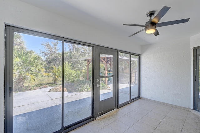 unfurnished sunroom with ceiling fan