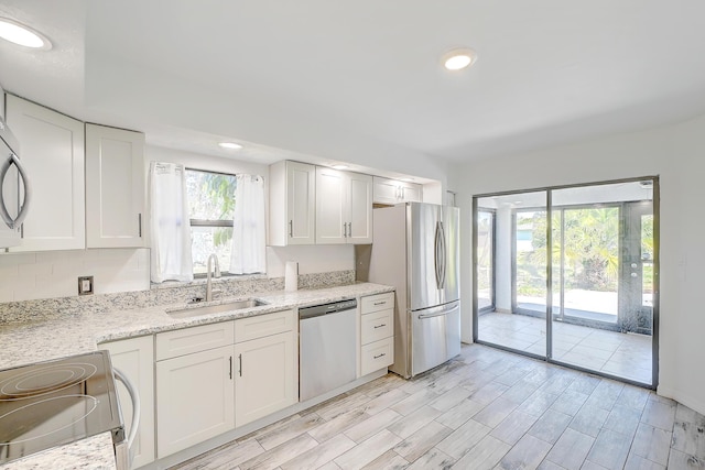 kitchen featuring recessed lighting, white cabinetry, stainless steel appliances, and a sink