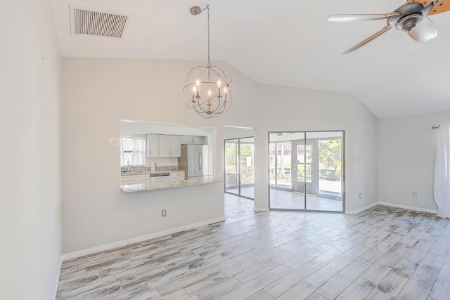 unfurnished living room featuring visible vents, baseboards, light wood-type flooring, ceiling fan with notable chandelier, and a sink