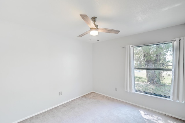 unfurnished room featuring carpet flooring, a ceiling fan, and baseboards