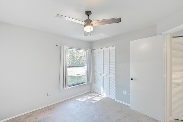 unfurnished bedroom featuring a closet, carpet flooring, a ceiling fan, and baseboards