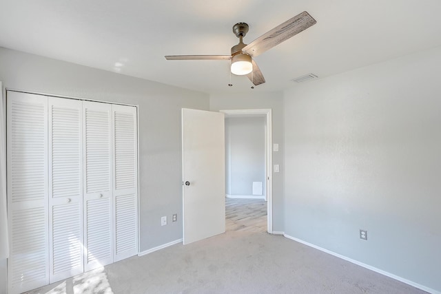 unfurnished bedroom featuring visible vents, ceiling fan, baseboards, light carpet, and a closet