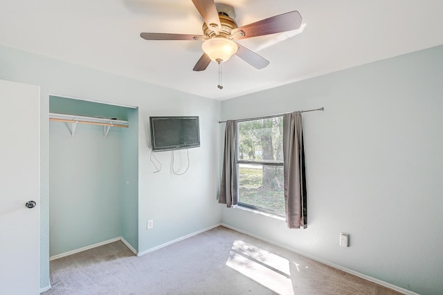 unfurnished bedroom featuring a ceiling fan, baseboards, a closet, and light carpet