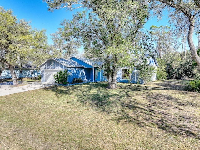 view of front facade featuring concrete driveway, an attached garage, and a front lawn