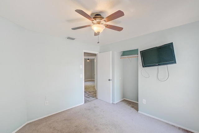 unfurnished bedroom with visible vents, baseboards, light colored carpet, a closet, and a ceiling fan