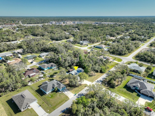 birds eye view of property featuring a residential view and a wooded view