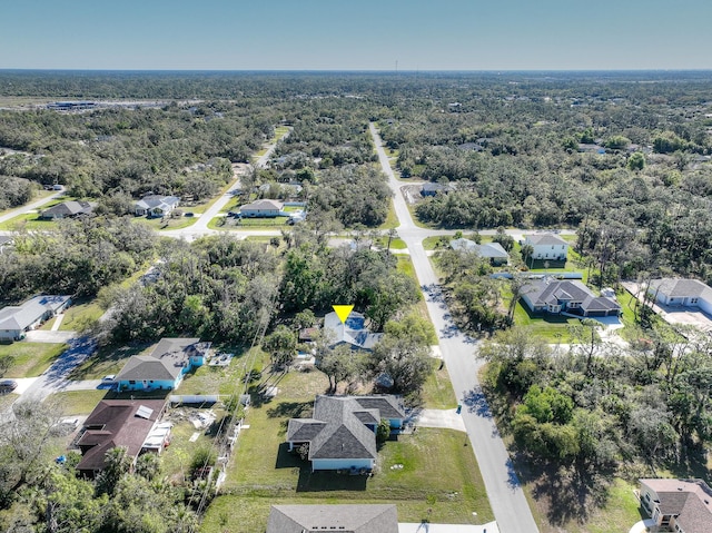 drone / aerial view with a wooded view and a residential view