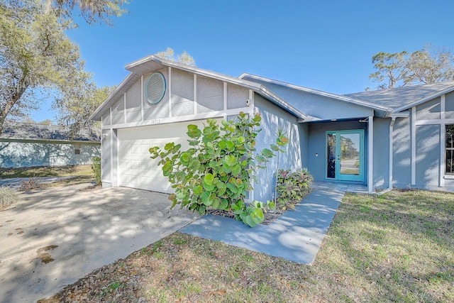 view of home's exterior featuring stucco siding, driveway, and a garage