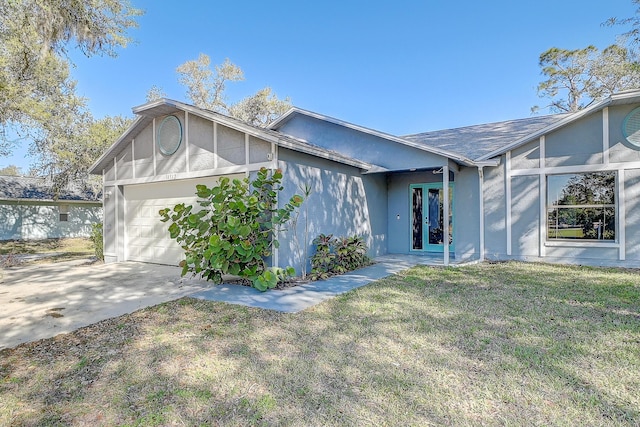 view of front of home with an attached garage, stucco siding, concrete driveway, a front lawn, and french doors