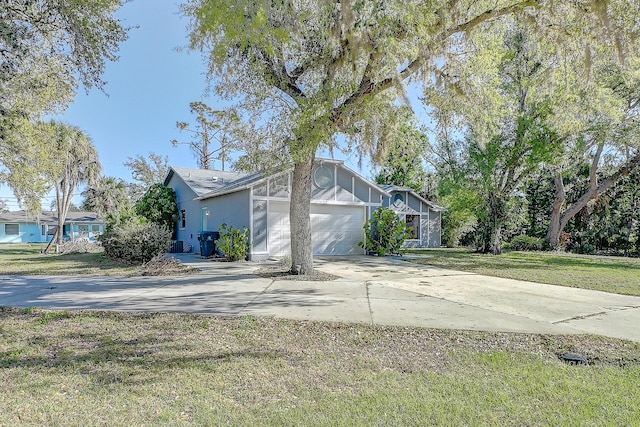 view of front of house featuring driveway, an attached garage, and a front lawn