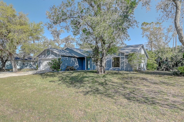 view of front of house with a front yard, an attached garage, and driveway