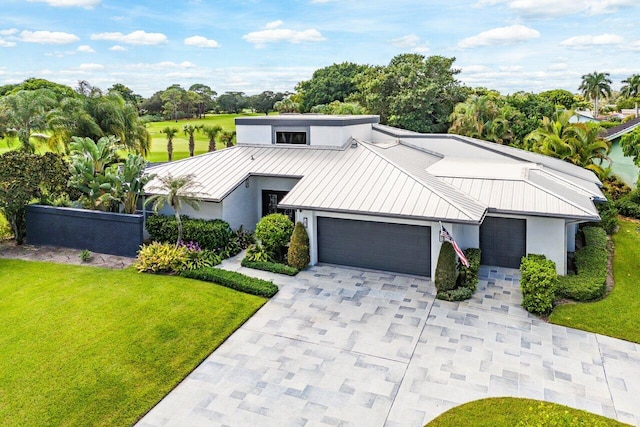 view of front of house featuring metal roof, decorative driveway, a standing seam roof, and an attached garage